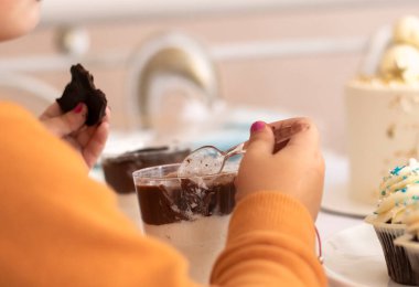 Tatlı yiyen tatlı kız. Tatlıyı biraz fazla kaçırır. Çocuklara beyaz şekere bağımlı olma kavramı. Yüksek kalite fotoğraf