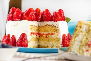 Seçici odaklanma. Bayramlık çilekli pasta. Ev yapımı çilekli pasta kesimi. Taze çilekle süslenmiş çilekli turta tabakta duruyor. Dondurma ve çilekli dondurma. Bir parça kes.. 