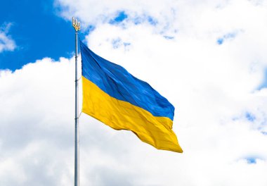  Ukrayna 'nın güzel renkli ulusal bayrağı kumaş dokusunda, göç, politika ve Ukrayna' daki savaş kavramında. Gökyüzünün şeffaf arka planında Ukrayna bayrakları. Semboller. bağımsız ülke
