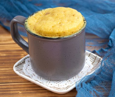 Vanilyalı kek mikrodalgada ısıtılır. Kahve fincanında ev yapımı kek. Bardakta mini kek. Bir kişilik bisküvi keki. Kolay pişirme konsepti, mikrodalga fırın. Vanilyalı kek. Vanilyalı tatlı. yiyecek arka planı