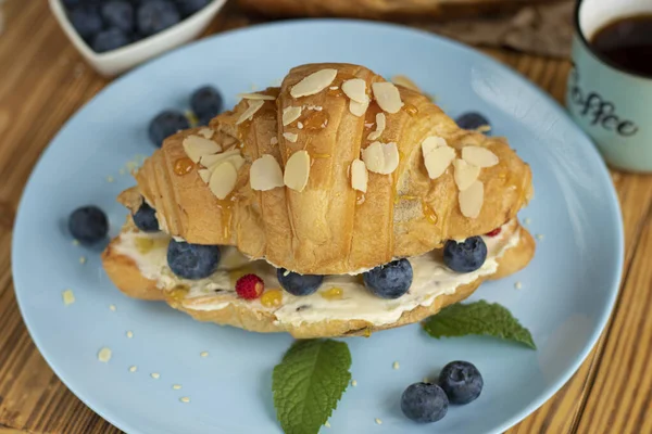 Peynirli, roka ve böğürtlenli kruvasan sandviç. Klasik Amerikan kahvaltısı. Fransız kruvasanı ve taze böğürtlen. Krem peynirli yaban mersini. Kruvasan ve kahve. Estetik tatlı.
