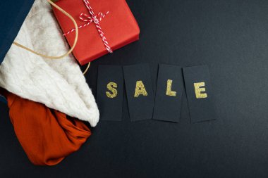 Noel Baba şapkası ve Noel süslemesi ve siyah arka planda satılık mektuplar. Uzayı kopyala Üst Manzara. Noel satış kavramı.