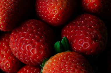 Olgun çileklerin makro fotoğrafları. Geçmişi ve dokuları. Yatay fotoğraf. Olgun meyve.