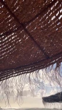 Doğal maddelerden yapılmış rüzgar güdümlü şemsiye. Rüzgarın yumuşak hareketi. Dikey video.