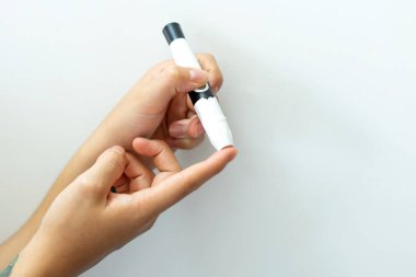 Glikoz testi için kan almak isteyen bir kadının elleri..