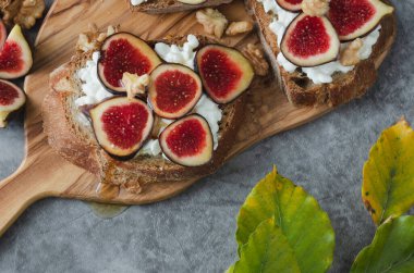 Bir tabak meyve, bir kavanoz bal ve ceviz. Sahne sıcak ve davetkar, bal ve meyve tatlı ve sağlıklı bir atıştırmalık oluşturuyor.