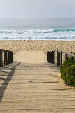 Portekiz 'de güneşli bir günde sabah Comporta sahiline tahta yol
