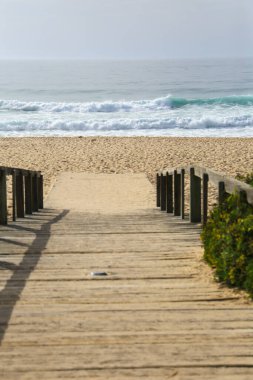 Portekiz 'de güneşli bir günde sabah Comporta sahiline tahta yol