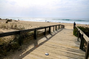 Comporta, Grandola, Portugal- 28 Ekim 2022: Portekiz 'de güneşli bir günde Comporta plajına giden ahşap yol