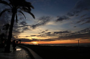 Santa Pola, Alicante, İspanya 'da sonbaharda gün doğumunda sahil kenarında gezinti