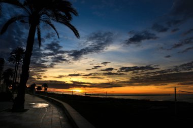 Santa Pola, Alicante, İspanya 'da sonbaharda gün doğumunda sahil kenarında gezinti