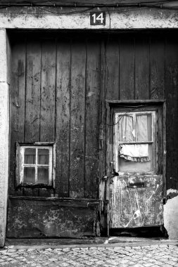 Lisbon, Portugal- November 18, 2022:Old wooden door with curtain and wrought iron details in Lisbon city, Portugal