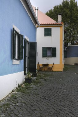 Narrow and colorful cobblestone street, majestic facades, windows and balconies of the old village of Queluz, Portugal