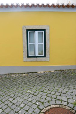 Old colorful and bright typical facade in Lisbon with beautiful white window
