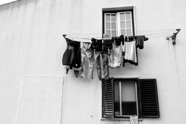 Lisbon, Portugal- November 21, 2022:Old chipped facade with clothesline and hanging clothes