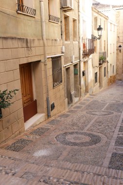 Relleu, Alicante, Spain- February 5, 2023: Narrow pebbled street and facades in Relleu, Alicante, Spain