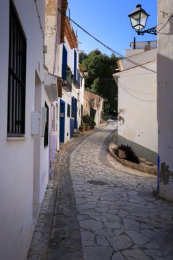 Finestrat, Alicante, Spain- February 5, 2023:Narrow cobbled street and beautiful facades in Finestrat village, Alicante, Spain