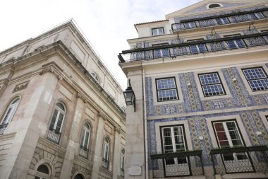 Old colorful and bright typical facade in Lisbon with beautiful white windows