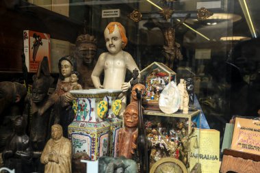 Lisbon, Portugal- November 22, 2022: Showcase of vintage bookstore called Sa Da Casa with old religious items