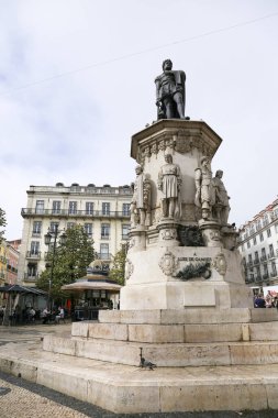 Lisbon, Portugal- November 4, 2022: Tall bronze statue of Luis de Camoes writer on a lioz limestone pillar in Camoes Square