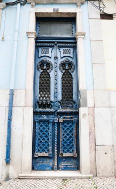 Lizbon, Portekiz- 21 Ekim 2022 Lizbon 'da eski ahşap kapı ve beyaz cephe. Kapıya metal yazmışlar..