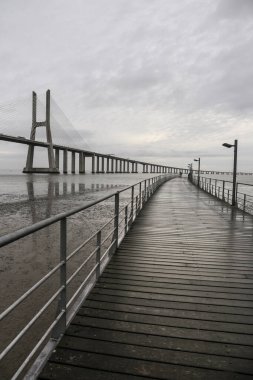 Lizbon 'daki Vasco da Gama köprüsünün yanındaki Tagus Nehri kıyısında bir iskele.