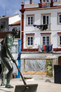 Alcochete, Lisbon, Portugal- October 21, 2022: Large bronze statue of a Salineiro, a salt worker. By Francisco Simoes. clipart