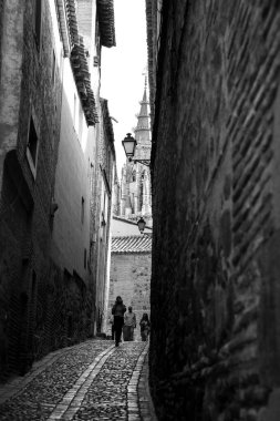 Toledo, İspanya - 6 Ekim 2022 Toledo 'daki dar sokaklar ve tarihi evler. Arka plandaki Katedral.