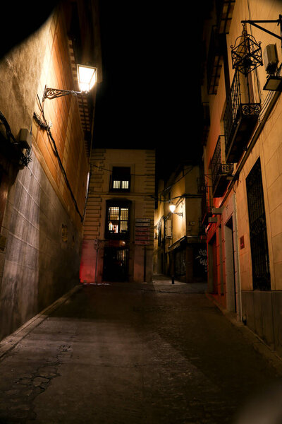 Toledo, Spain- October 6, 2022: Narrow streets and Facades of historic houses at night in the old town of Toledo , Spain
