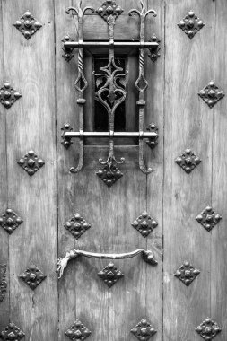 İspanya 'nın eski ahşap kapısında kanatları olan mitolojik ejderha şekilli güzel bir kapı kolu.