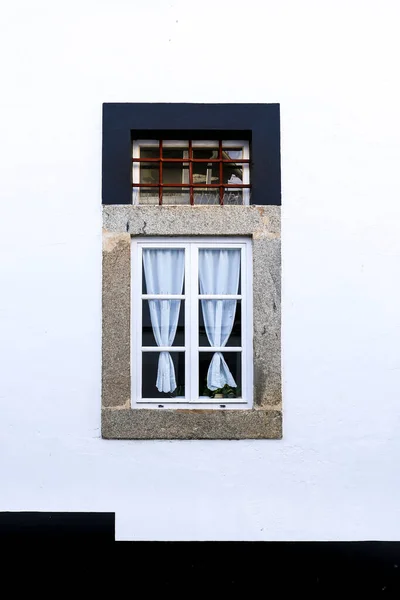 白木製の窓とエヴォラ町の白塗りのファサードのカーテンを持つ典型的なポルトガルのファサード — ストック写真