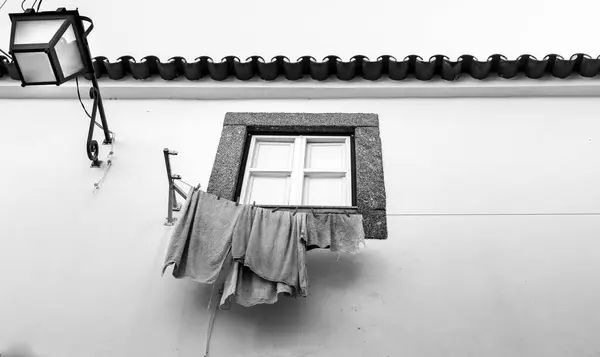 ぶら下がり服の典型的なポルトガルの窓 モノクローム写真 — ストック写真