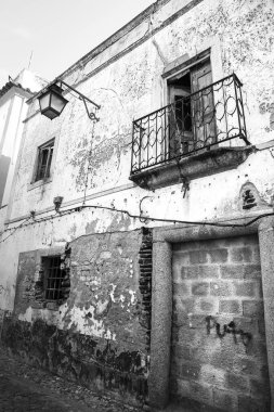 Evora, Portekiz- 10 Ekim 2022: Hasarlı demir balkon ve klasik sokak lambası cephesi