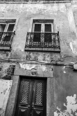 Portekiz 'in Evora kasabasında beyaz çentikli ve ahşap pencereli eski bir ev.