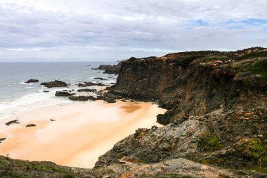 Portekiz, Alentejo sahilinde kayalıkları ve uçurumları olan Pedra da Bica plajı.