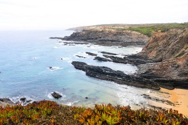 Portekiz, Alentejo sahilinde kayalıkları ve uçurumları olan Cavaleiro plajı.