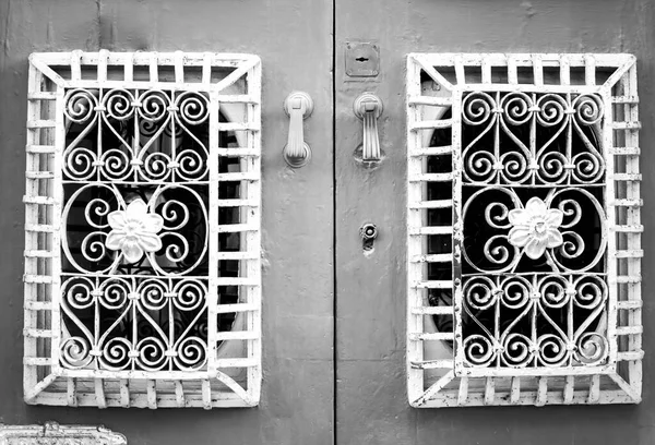ポルトガルのタビラに花をモチーフにした鍛造金属グリル付きの木製ドア — ストック写真