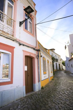 Ferragudo, Portugal- 20 Ekim 2022: Narrow Cobblestone caddeleri ve Portekiz 'in Ferragudo kasabasındaki tipik Portekiz cepheleri
