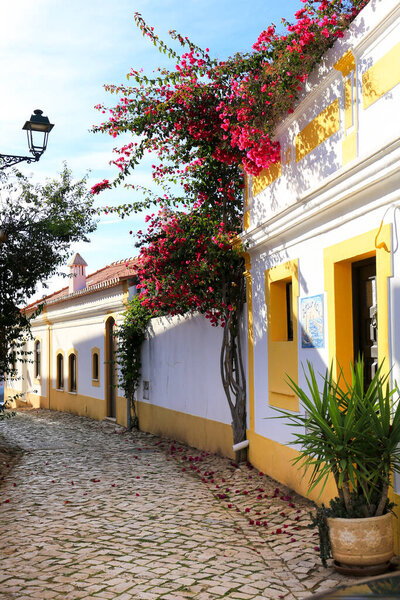 Ferragudo, Portugal- October 20, 2022: Narrow Cobblestone streets and typical Portuguese facades in Ferragudo town, Portugal