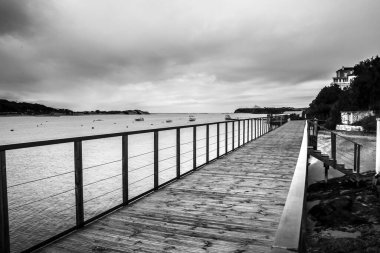 Vilanova de Milfontes, Alentejo, Portekiz 'de bulutlu bir günde Mira Nehri üzerindeki eski ahşap iskele.