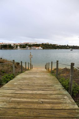Vilanova de Milfontes, Alentejo, Portekiz 'de bulutlu bir günde Mira Nehri üzerindeki eski ahşap iskele.