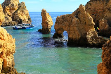 Lagos, Algarve, Portugal- 20 Ekim 2022: Portekiz 'in Algarve kentindeki Ponta da Piedade Kireçtaşı oluşumlarını ve koyları ziyaret eden insanlarla dolu turistik tekneler