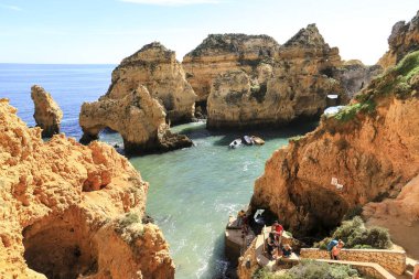 Lagos, Algarve, Portugal- 20 Ekim 2022: Portekiz 'in Algarve kentindeki Ponta da Piedade' nin doğal özelliklerini, kayalıklarını ve kireçtaşı oluşumlarını ziyaret eden insanlar