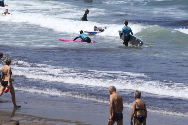 Zumaia, Gipuzkoa, İspanya - 13 Ağustos 2023: İspanya 'nın Zumaia kentindeki Itzurun Sahili' nde güzel havanın tadını çıkaran sörfçüler