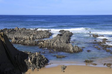 Portekiz, Alentejo sahilinde siyah bazalt kayalıkları olan Almograve plajı.