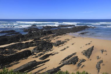 Portekiz, Alentejo sahilinde siyah bazalt kayalıkları olan Almograve plajı.