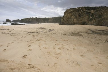 Porto Covo, Alentejo, Portekiz 'de fırtınalı ve rüzgarlı bir günde Samoqueira plajı.