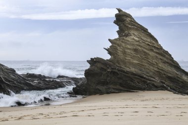 Porto Covo, Alentejo, Portekiz 'de fırtınalı ve rüzgarlı bir günde Samoqueira plajı.