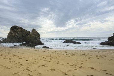 Porto Covo, Alentejo, Portekiz 'de fırtınalı ve rüzgarlı bir günde Samoqueira plajı.