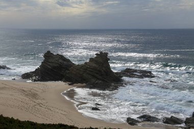 Porto Covo, Alentejo, Portekiz 'de fırtınalı ve rüzgarlı bir günde Samoqueira plajı.